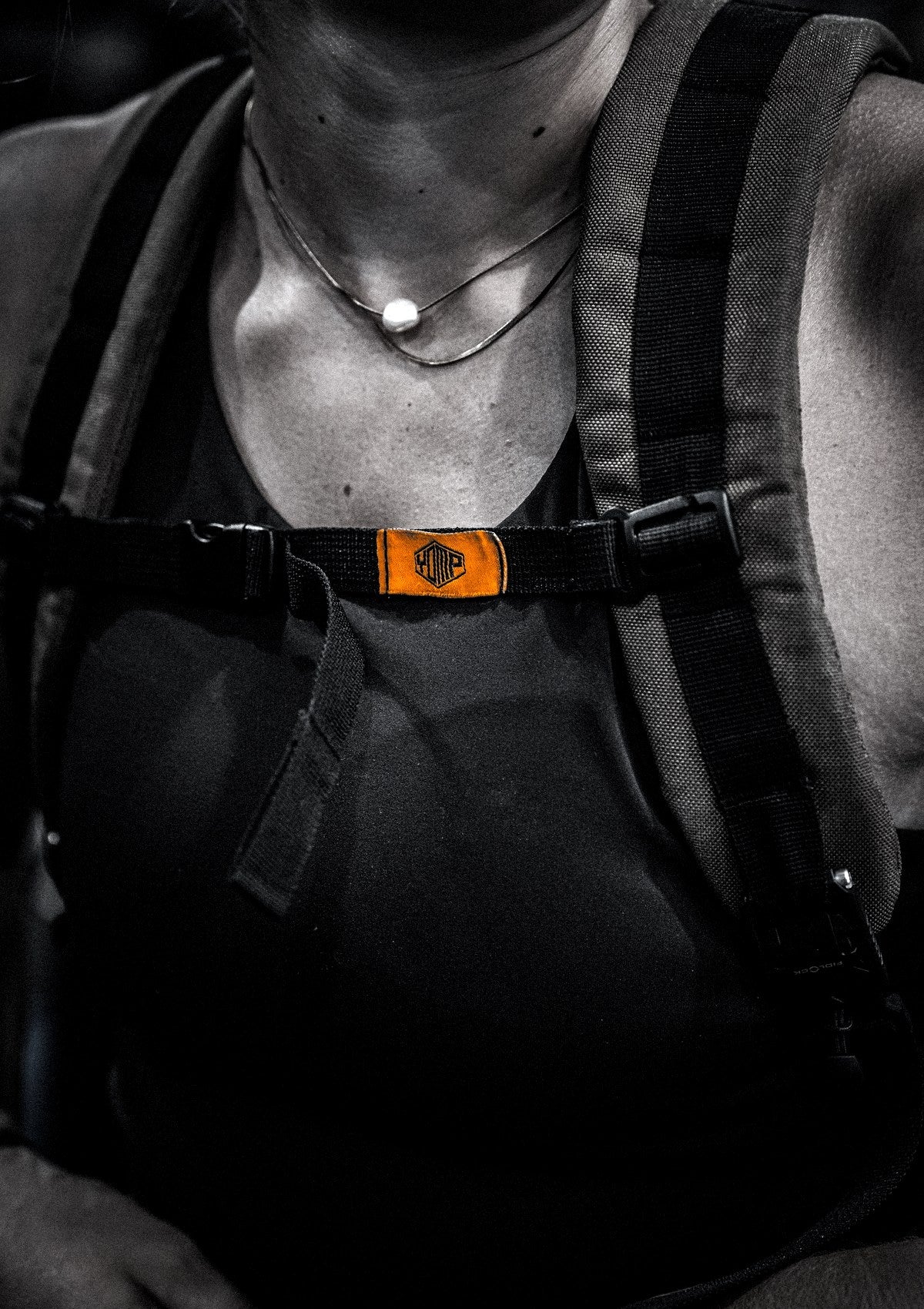 Close-up of a YOMP rucking backpack's sternum strap and orange label